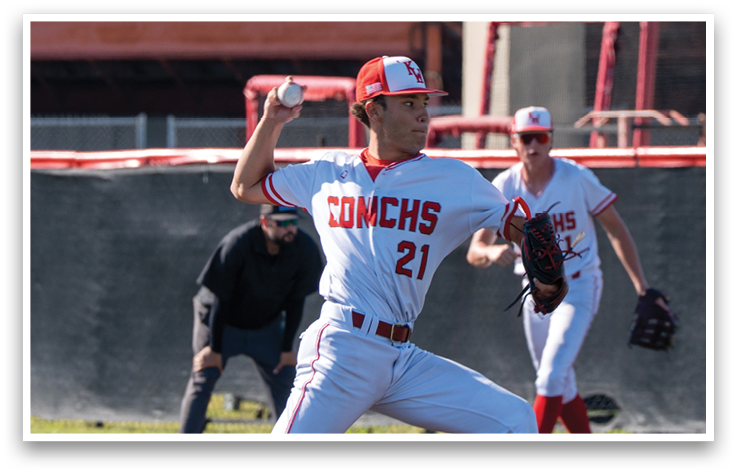 A baseball player in a white and red uniform is throwing a ball. Description generated by AI