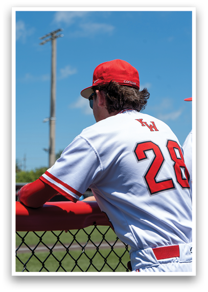 A baseball player wearing a red and white uniform. Description generated by AI
