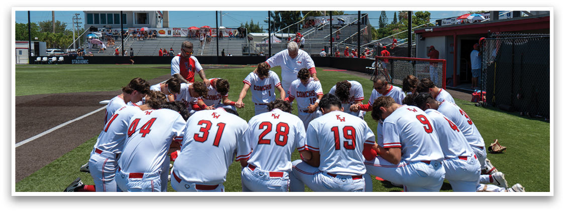 Baseball players kneeling on the field. Description generated by AI