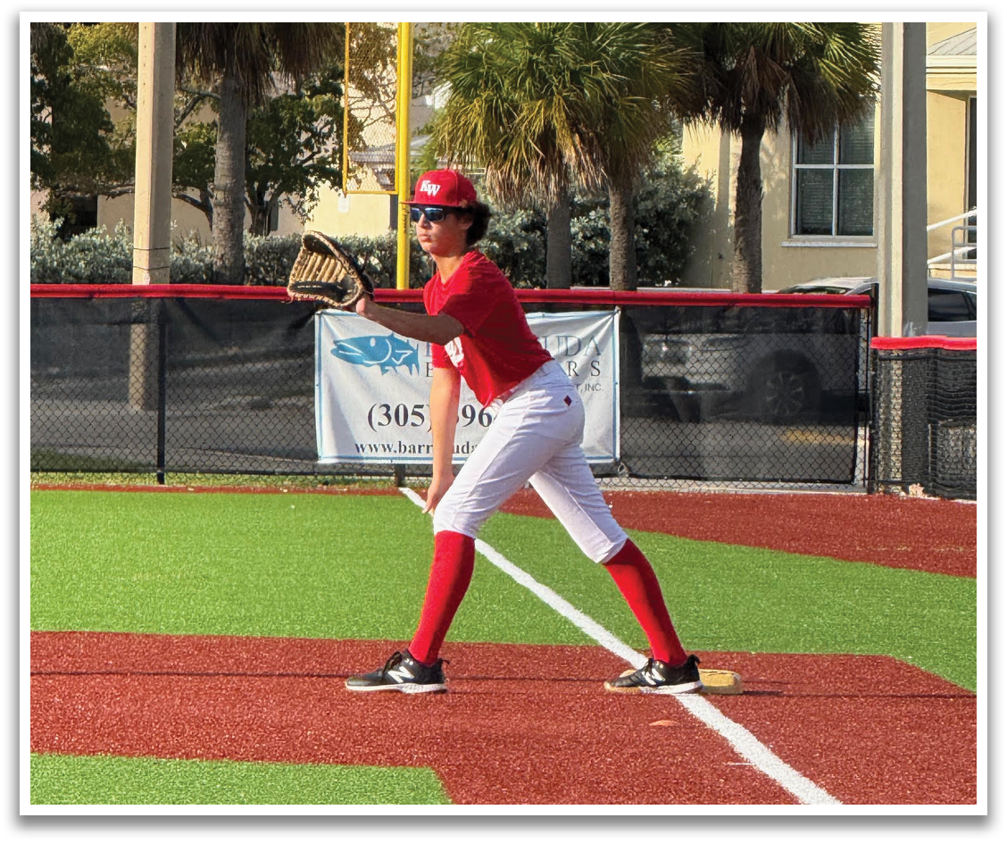 A baseball player in a red shirt and white pants is holding a baseball bat and standing on a baseball field. AI generated content