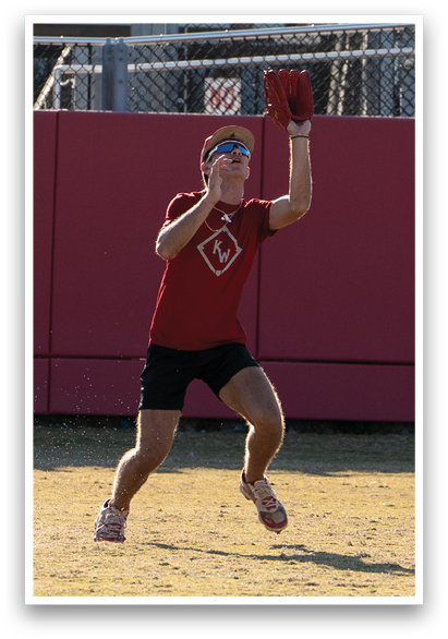 A man wearing a red shirt and black shorts is catching a ball. AI generated content