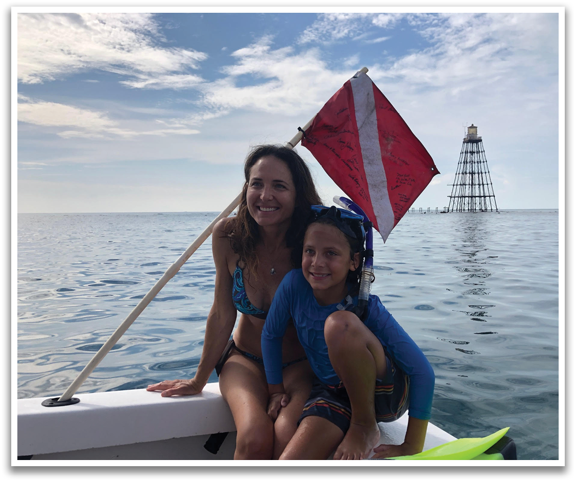 A woman and a child are sitting on a boat, with the woman holding a red and white flag. They are both wearing bathing suits. AI generated content
