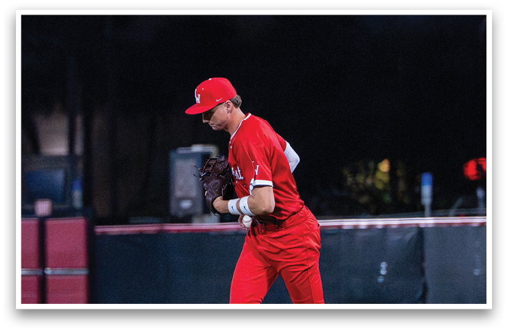 A baseball player in a red uniform is standing on a field with a baseball glove. AI generated content