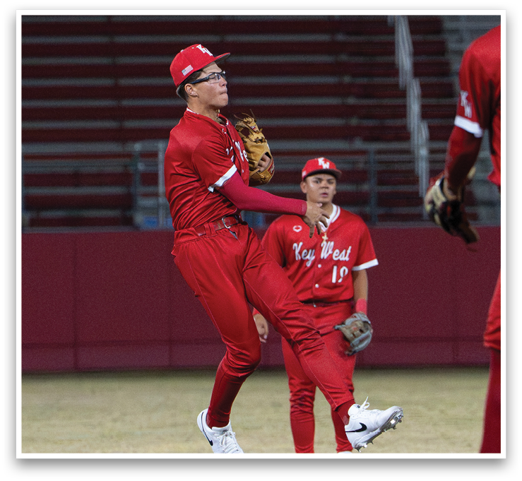 A baseball player in a red uniform jumps in the air to catch a ball. AI generated content