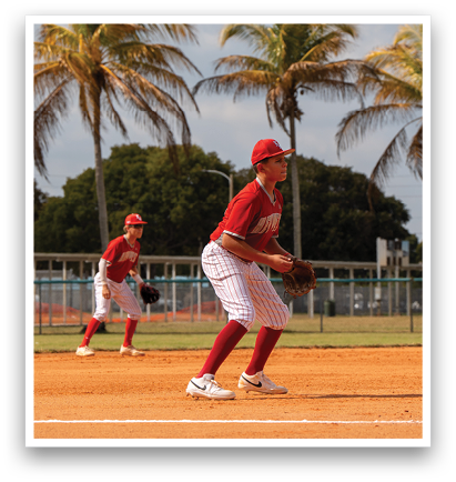 Two baseball players are on the field, one wearing a red shirt and the other wearing a red and white shirt. The player in the red shirt is holding a baseball glove, ready to catch the ball. AI generated content