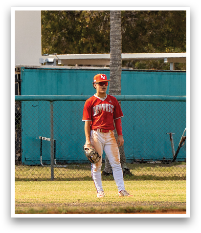 A baseball player wearing a red shirt and white pants stands on a field. AI generated content