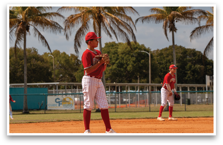 A baseball player in a red shirt and white pants is standing on a dirt field, holding a baseball glove. AI generated content