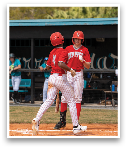 Two baseball players are on the field, one wearing a red jersey and the other wearing a red helmet. They are talking to each other. AI generated content