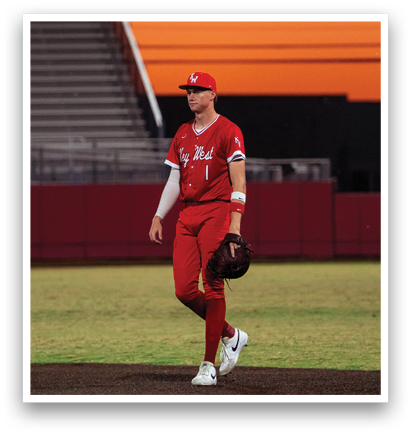 A baseball player in a red uniform walks across a field during a game. AI generated content