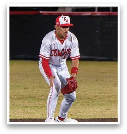 A baseball player in a white uniform is standing on the field, holding a baseball glove. AI generated content