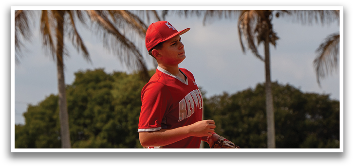 A baseball player in a red shirt and white pants is standing on a field, holding a baseball glove. AI generated content