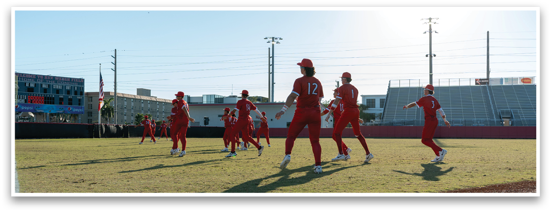 A group of people wearing red uniforms are standing on a baseball field. AI generated content