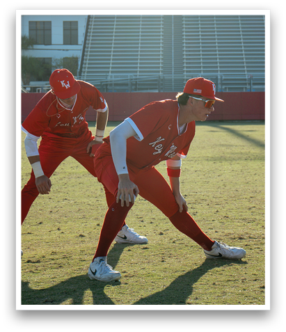 Two baseball players in red uniforms are standing on a field. AI generated content