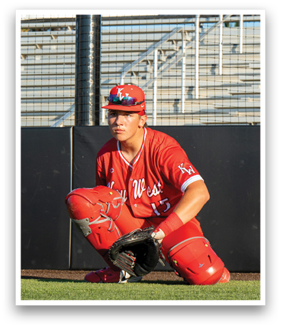 A baseball player wearing a red jersey and a red hat is kneeling on the ground. AI generated content