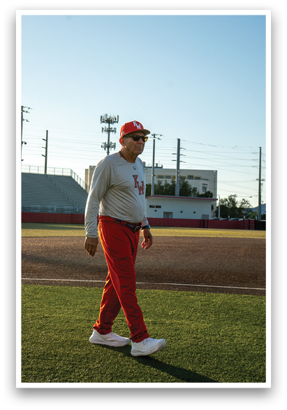 A man wearing a red shirt and red pants is walking on a baseball field. AI generated content