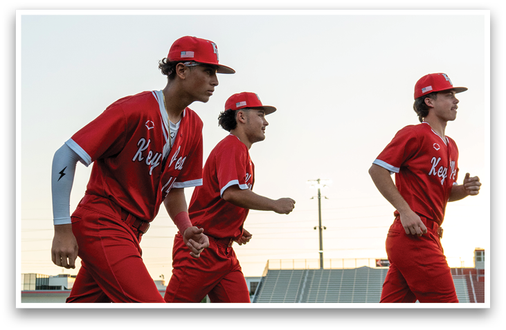 Three baseball players wearing red uniforms and red hats are walking across a field. AI generated content