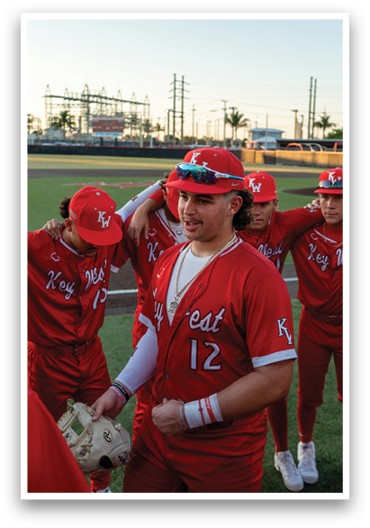 A group of baseball players wearing red jerseys and red hats are standing together on a field. AI generated content