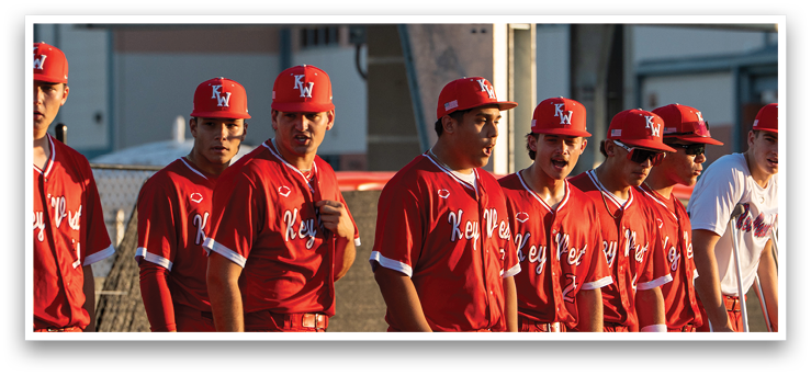 A group of baseball players wearing red uniforms are walking on a field. AI generated content
