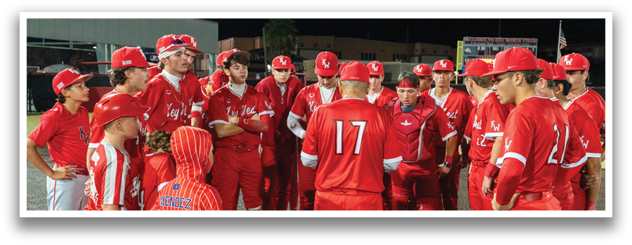 A group of baseball players wearing red uniforms are gathered on the field. AI generated content