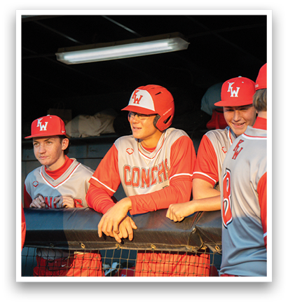 A group of baseball players wearing red and white uniforms are sitting on a bench. AI generated content