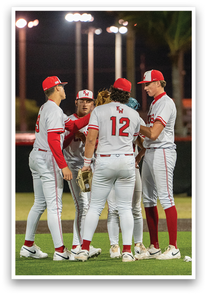 Four baseball players wearing red and white uniforms are standing on a field. AI generated content