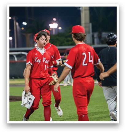 Three baseball players wearing red uniforms are walking on the field. AI generated content