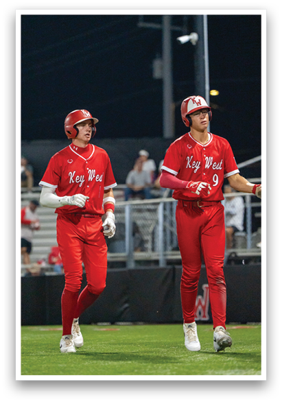 Two baseball players wearing red uniforms walk on the field. AI generated content