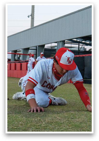 A baseball player is kneeling on the ground with his hands on his knees. AI generated content