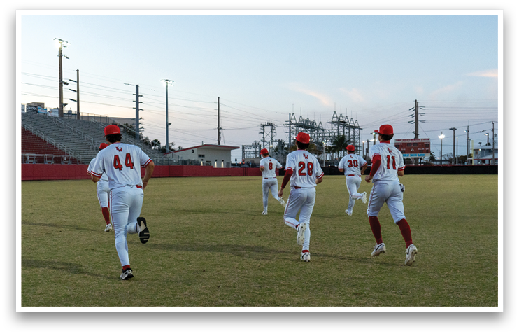 A group of baseball players in uniforms are running on a field. AI generated content