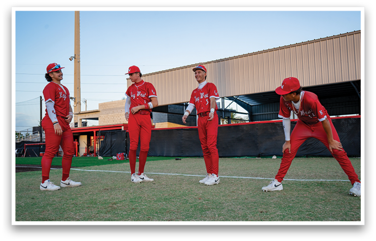 Four baseball players in red uniforms are standing on a field. AI generated content