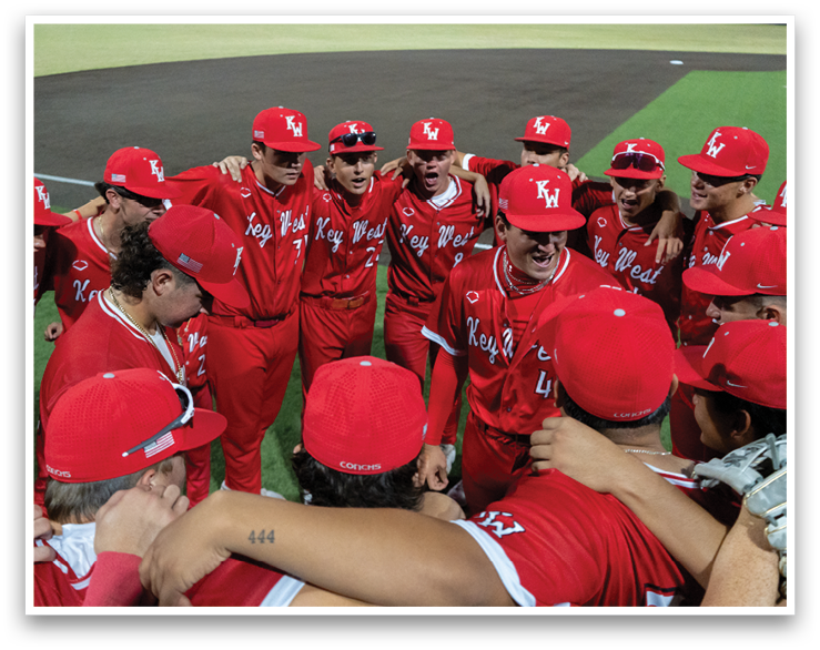 A group of baseball players wearing red hats and red uniforms are hugging each other on a field. AI generated content