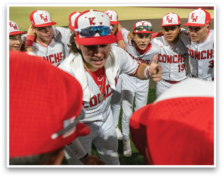 A group of baseball players wearing red and white uniforms are huddled together on the field. AI generated content