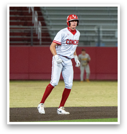A baseball player wearing a red helmet and white uniform is walking on the field. AI generated content