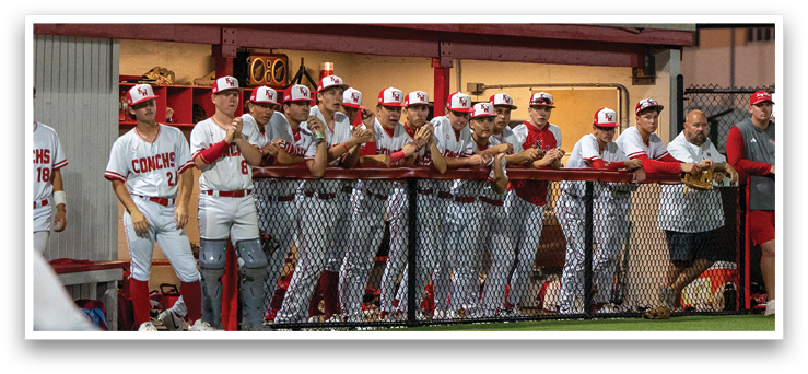 Baseball players in uniforms are standing on a field, some of them wearing red and white. A man is pitching a baseball, and the players are watching him. AI generated content