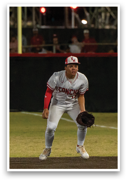 A baseball player wearing a white uniform and red socks is standing on the field, holding a baseball glove. AI generated content