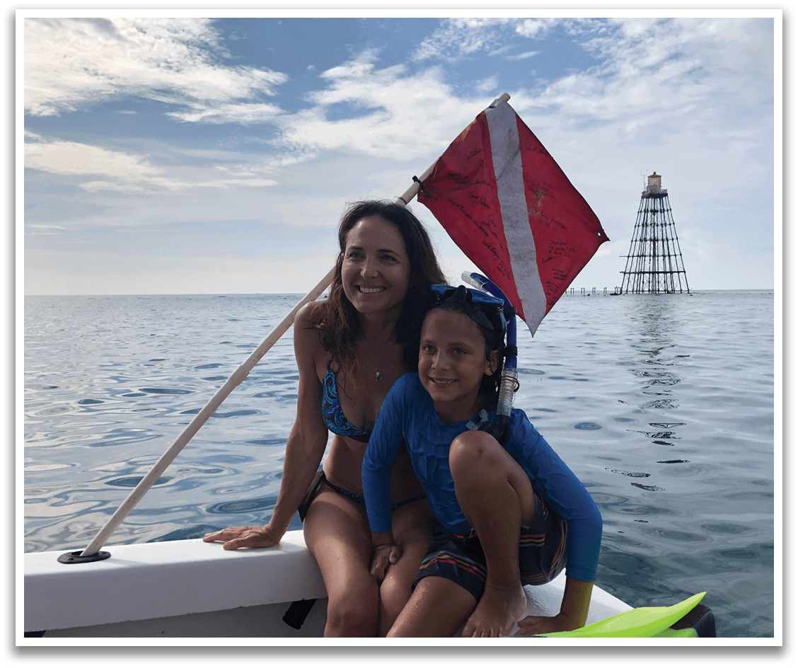 A woman and a child are sitting on a boat, with the woman holding a red and white flag. They are both wearing bathing suits. AI generated content