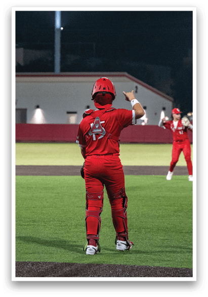 A baseball player in a red uniform stands on a field, holding his glove in the air. AI generated content