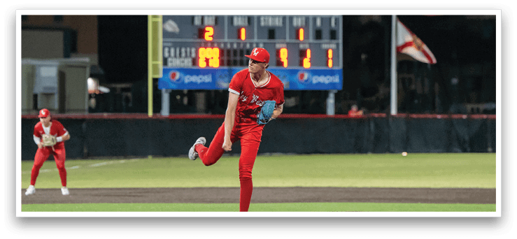 A baseball pitcher in a red uniform is on the mound, getting ready to throw the ball. AI generated content