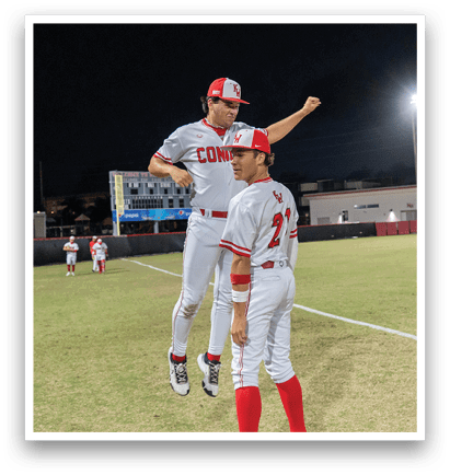 Two baseball players are jumping in the air on a field. AI generated content