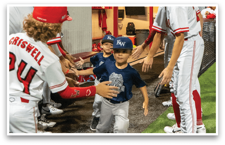 A group of baseball players shake hands with a young boy in a blue shirt. AI generated content