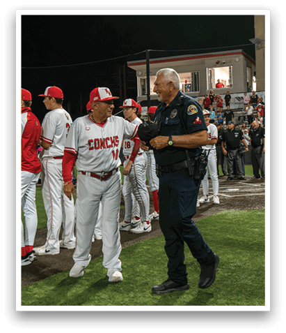 A police officer and a baseball player are shaking hands on a field. AI generated content