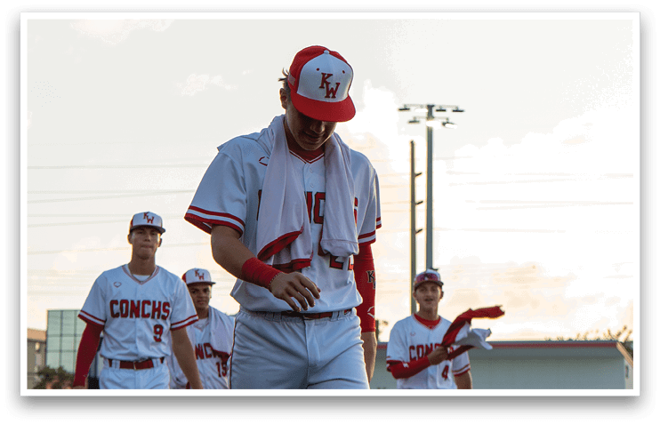A group of baseball players wearing red and white uniforms are walking on a field. AI generated content