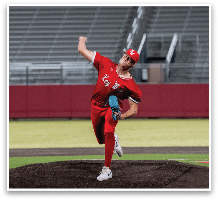 A baseball player in a red uniform is pitching a ball on a field. AI generated content