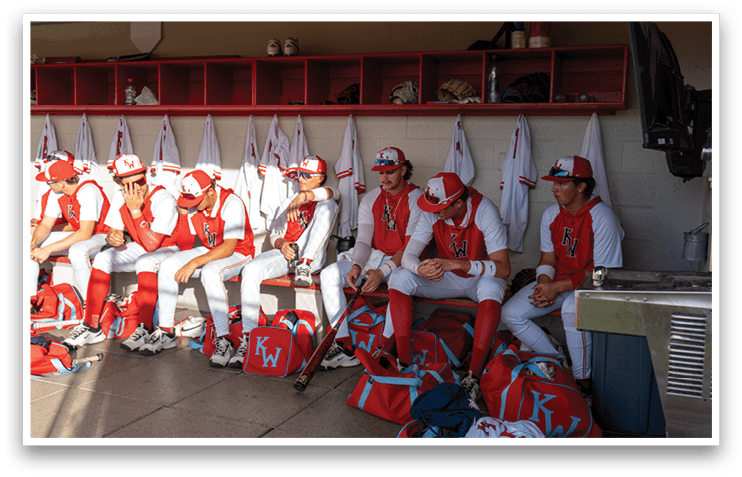 Baseball players sitting in a dugout, wearing red and white uniforms. AI generated content