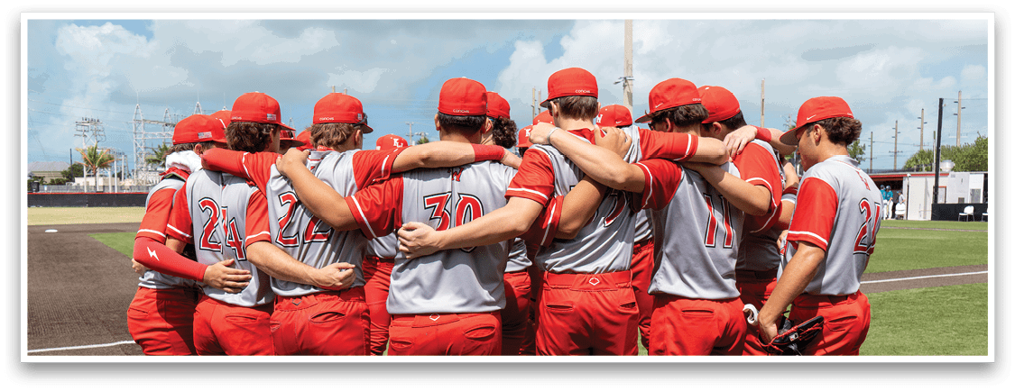 A group of baseball players wearing red and gray uniforms huddle together on the field. AI generated content
