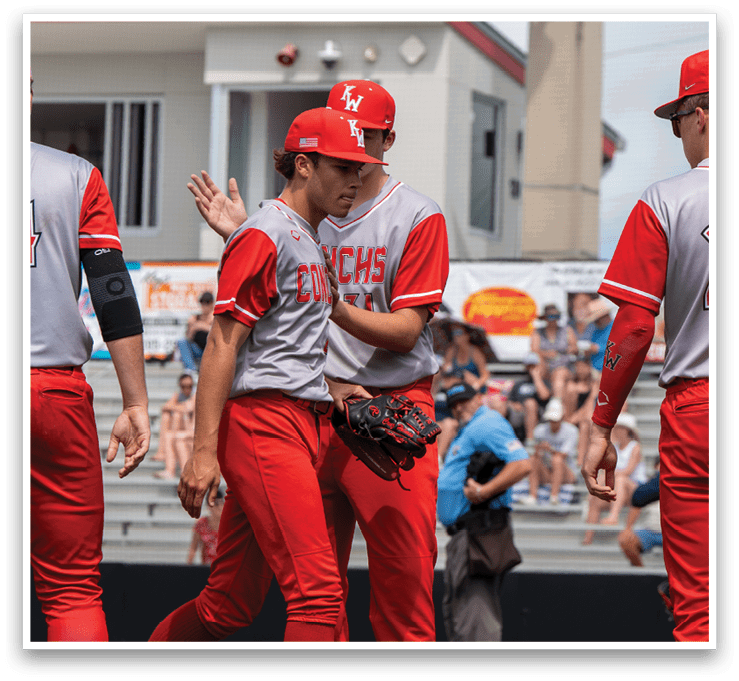 Baseball players wearing red and grey uniforms are walking on a field. One player is holding a baseball glove. AI generated content