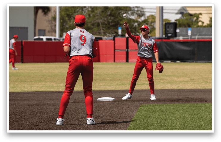 Two baseball players in red uniforms are standing on a field, one of them is holding a baseball glove. AI generated content