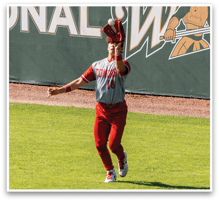 A person wearing a red shirt and red pants is catching a baseball. AI generated content
