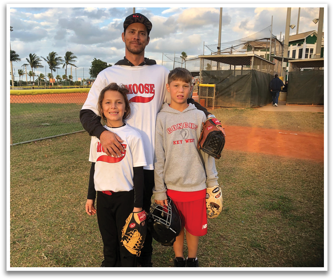 A man and two children pose for a picture on a baseball field. AI generated content