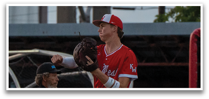 A baseball player wearing a red uniform and a white cap catches a ball. AI generated content